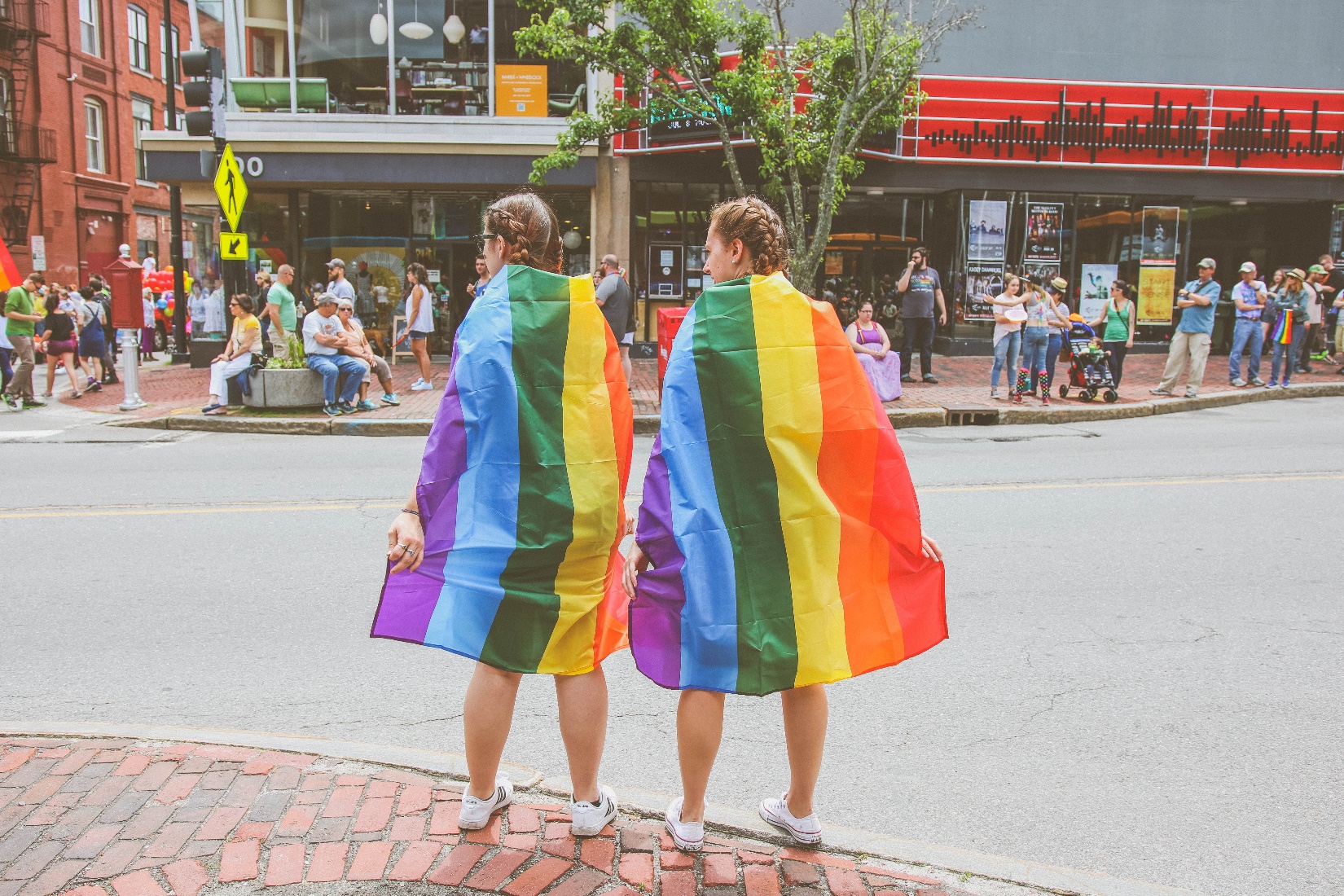 Two Women Wearing Rainbow Capes