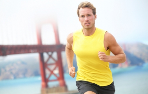 Man running in a yellow shirt by the Golden Gate Bridge