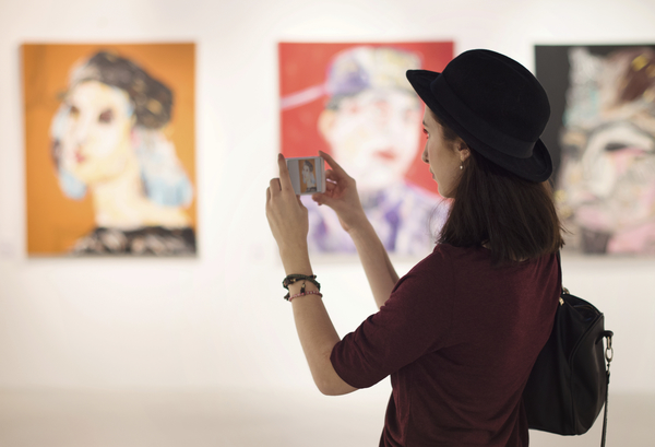 Woman taking a photo in an art gallery