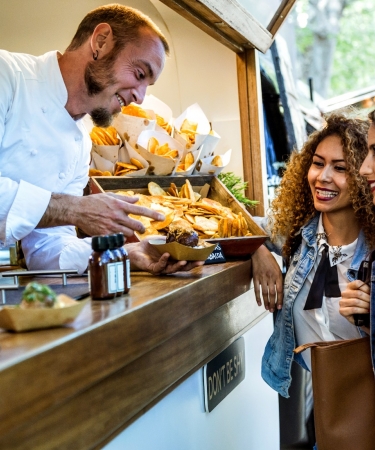 Food vendor showing three girls food
