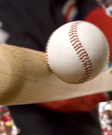 Close up of a baseball bat hitting a ball