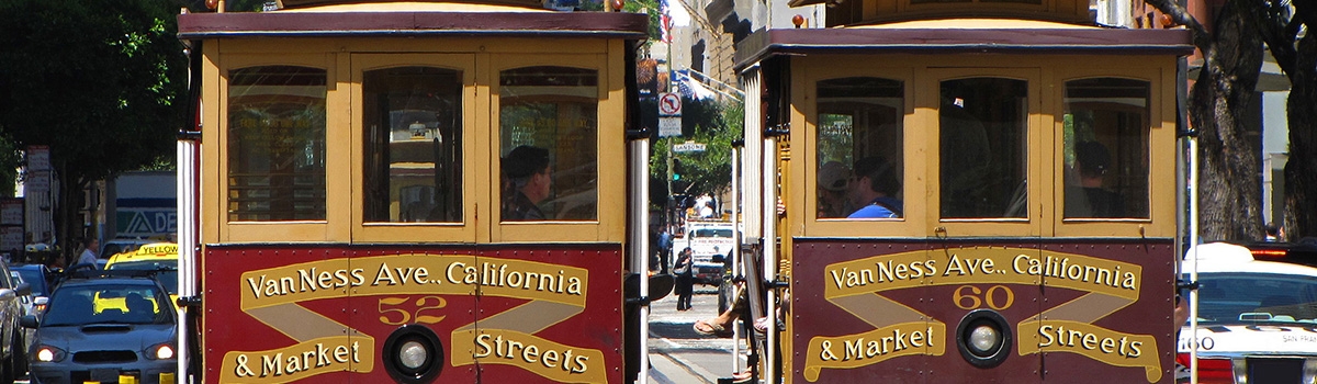 Two red cable cars on a street in San Francisco