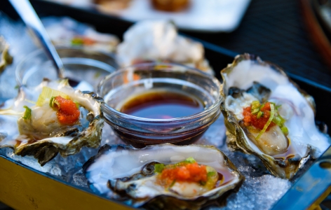 Oysters on a plate with sauce in the middle