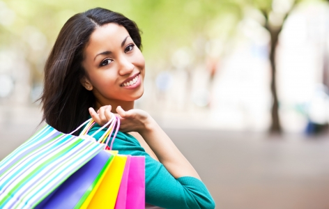 Woman holding colorful shopping bags over her shoulder