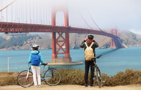 Couple on bicycles stopping to look at the Golden Gate Bridge - a San Francisco Attraction